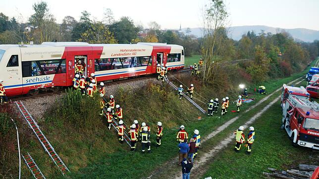 Um die große Höhe des Ausstiegs und den steilen Hang der Bahntrasse zu überwinden, haben die Feuerwehrleute Leitern mit improvisierten ...