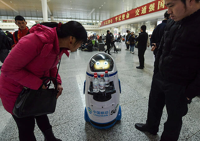 Ein Roboter serviert Mineralwasser an Passagiere auf dem Bahnhof in Hangzhou ind Ostchina.