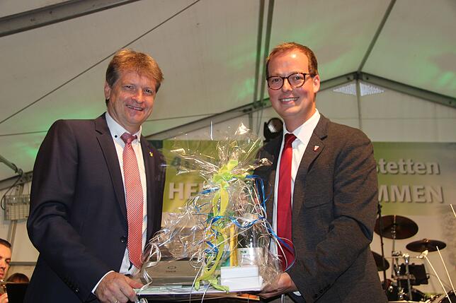 Landrat Günther-Martin Pauli (links) überreicht Bürgermeister Frank Schroft einen Geschenkkorb.