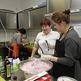 Sabine Tesche schnippelt Salat, Eva Pal lobt das Dessert, das Isabelle Arndt (von links) mit zubereitet hat.