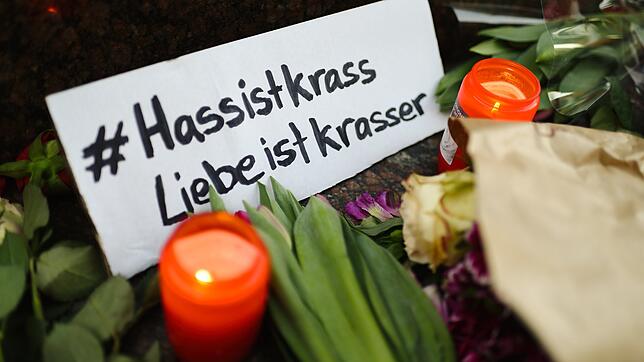 Kerzen und Blumen liegen am Brüder Grimm Denkmal am Marktplatz. Bei einem mutmaßlich rassistischen Anschlag hatte ein 43-jähriger ...
