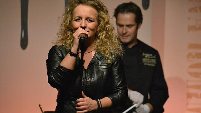 Während Christina Rommel über Schokolade singt, bereitet Chocolatier Dirk Beckstedde (im Hintergrund) die nächste Leckerei vor.