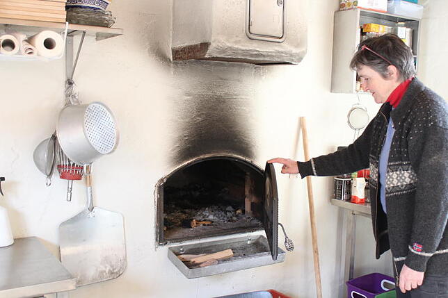 Sylvia Hummel am Backofen im Backhaus im Garten des ehemaligen Pfarrhauses. Das Backhaus wurde im vergangenen Jahr fertiggestellt. Bild: ...
