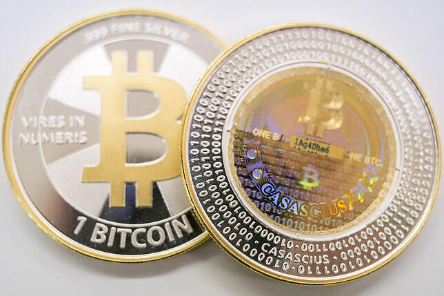 Die erste öffentlich gehandelte Kryptowährung ist der Bitcoin. Zwei Bitcoin-Münzen liegen bei der Firma Bitcoin Suisse AG auf einem Tisch.