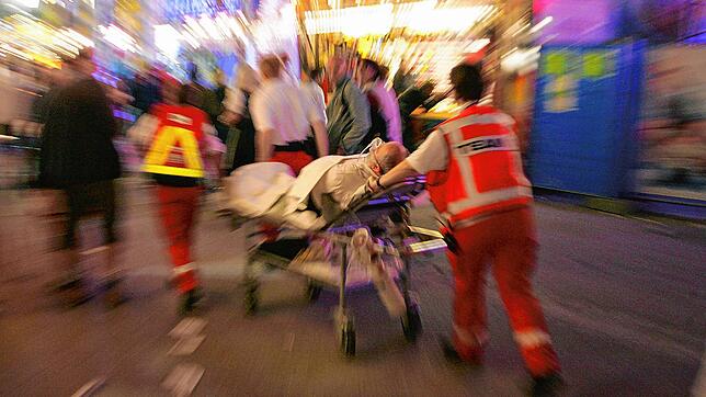 ARCHIV – Ein Patient wird am 22.09.2007 von ehrenamtlichen Sanitätern des Roten Kreuzes über das Oktoberfest in München (Bayern) ...