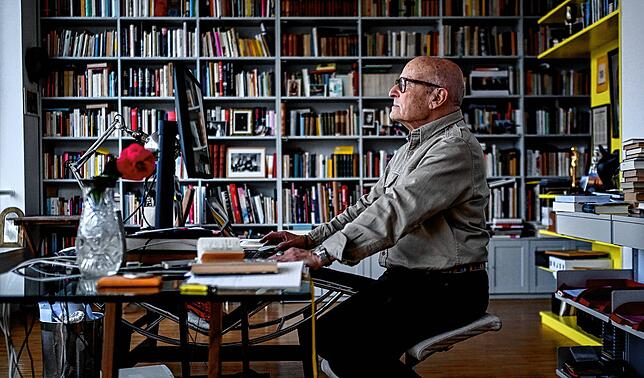 Der Regisseur Volker Schlöndorff sitzt an seinem Schreibtisch in seinem Arbeitszimmer.
