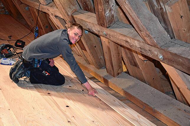 Ter Nyland von der Firma Holzbau Schmäh verlegt auf dem Dachboden der Kapelle ein neues Dielenbrett aus Weißtanne.