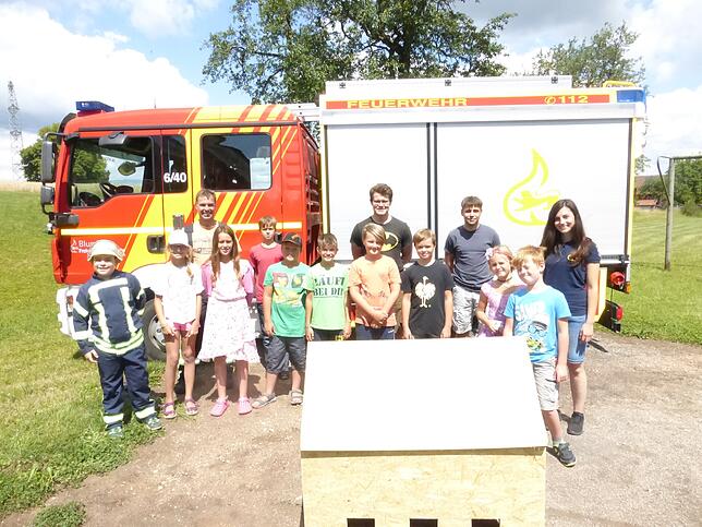 Zu Beginn des Komminger Ferienprogramms &bdquo;Wasser marsch&ldquo; versammeln sich die Teilnemer vor dem Feuerwehrauto.