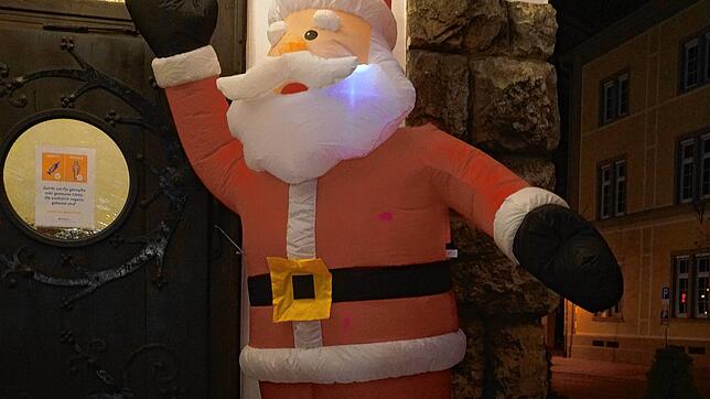 Ein &bdquo;luftiger&ldquo; Weihnachtsmann grüßt vor einem Restaurant.