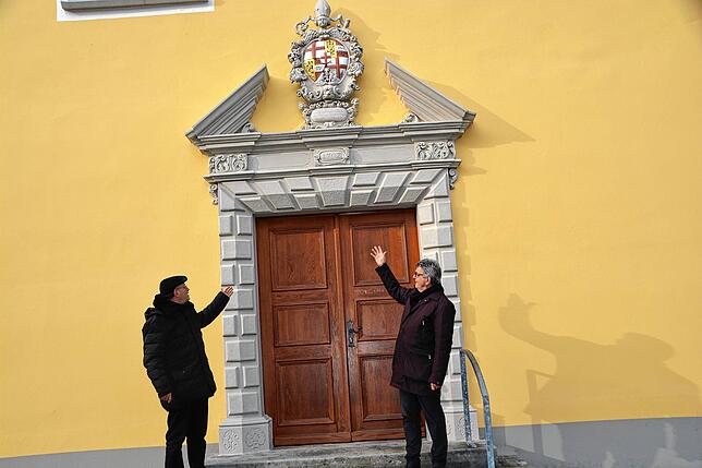 Pfarrer Matthias Schneider und Architekt Michael C. W. Günther (von links) präsentieren das Hauptportal der frisch sanierten Kapelle in ...