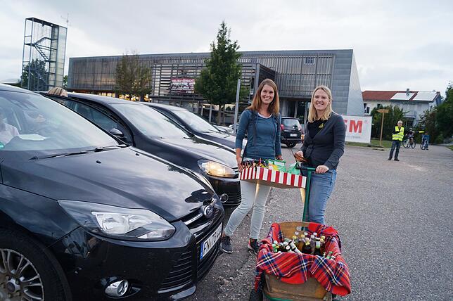 Sarah Kunle und Lisa Keller ziehen mit Bauchladen und Bollerwagen von Autofenster zu Autofenster und sorgen für frisches Popcorn und ...