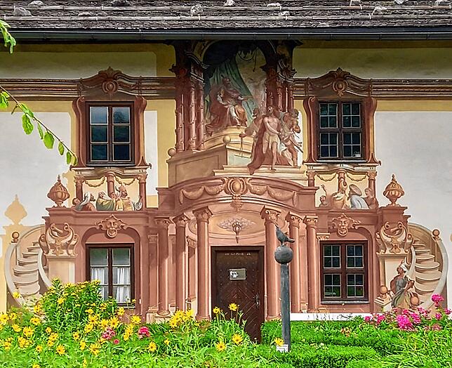Oberammergau ist bekannt für seine prächtig verzierten Hausfassaden, die &bdquo;Lüftlmalerei&ldquo;. Hier das Petrushaus.