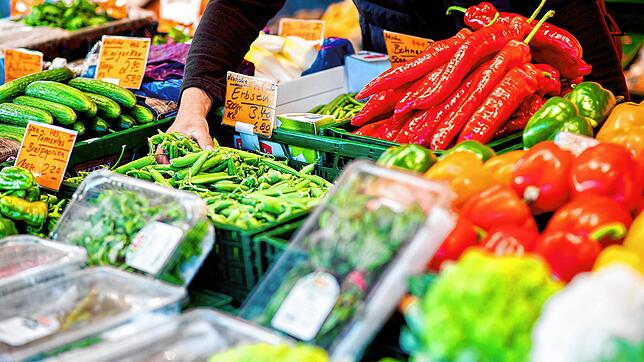 Ein Verkäufer greift an einem Obst- und Gemüsestand. Gemüse und Obst sind zuletzt teurer geworden. Noch mehr betrifft es aber Produkte ...