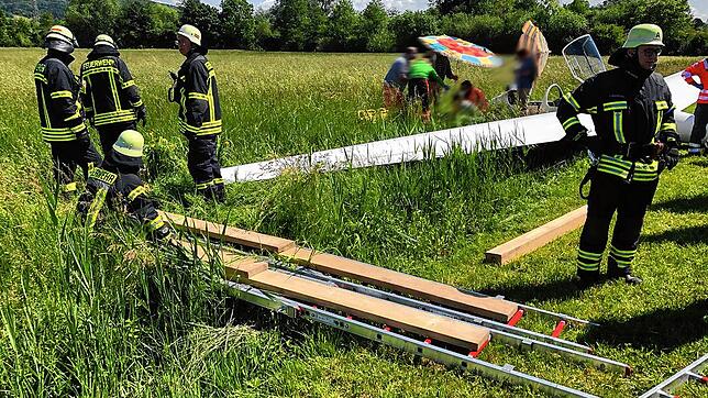 Die Einsatzkräfte der Feuerwehr unterstützten die Rettungssanitäter beim Transport des schwer verletzten Piloten zum Rettungsfahrzeug. ...