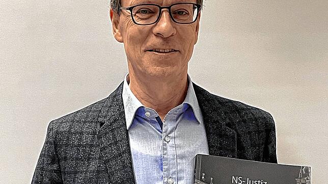 Thomas Kummle, der von 2006 bis 2020 Präsident des Amtsgerichts Freiburg war, mit dem Katalog „NS Justiz in Freiburg“.