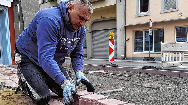 Jacek Czekaj verlegt die letzten Quadratmeter Pflaster in der Jakob-Kessenring-Straße. Die Granitsteine sind hier konisch geschnitten. ...