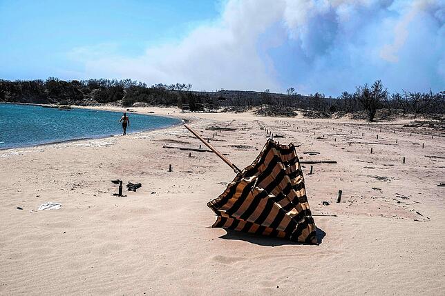 Ungewohnter Anblick: Zuvor ein Ort, an dem man sich gern aufhält, ist dieser Strand auf Rhodos nach einem Brand nahezu menschenleer. Im ...