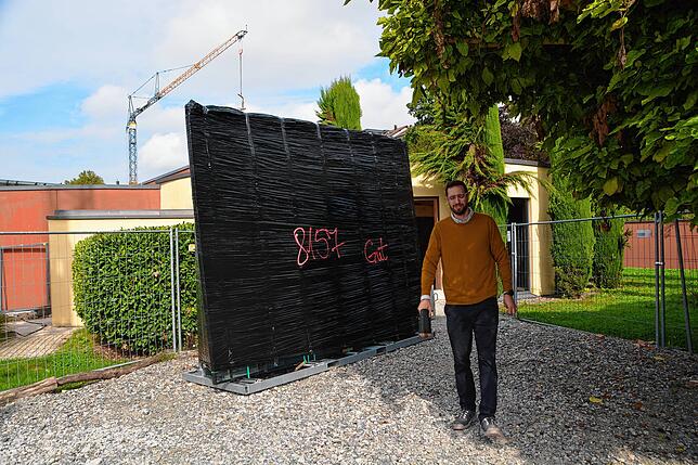 Architekt Jonas Neusch zeigt die Glasscheiben, die hier noch verpackt auf den Einbau warten.
