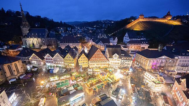 Die Stände des Weihnachtsmarkts Esslingen leuchten am Abend. Im Hintergrund ist die Esslinger Burg zu sehen. Hier gibt es alle Infos ...
