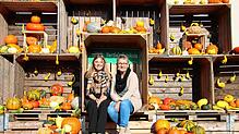 Monika Hertle (rechts) und Tochter Sophia in der Fotokiste vor dem Obsthof Hertle, umgeben von zahlreichen Kürbissen.