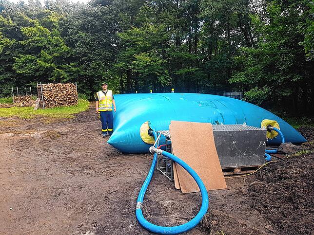 Auf einem planierten Platz wird eine provisorischen Trinkwasserversorgung errichtet.