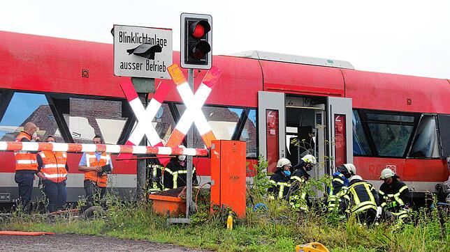 Die Halbschranke ist unten, das rote Blinklicht leuchtet.