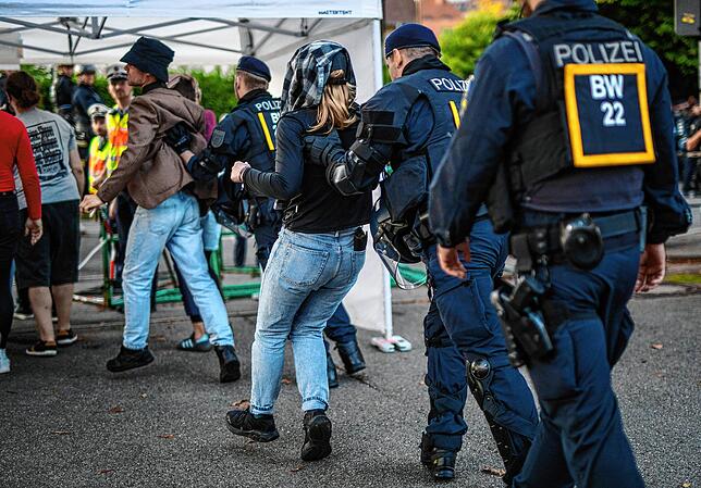 Polizeibeamte führen Störer aus der Halle, die die Diskussionsrunde mit Tübingens Oberbürgermeister Palmer (parteilos) und dem ...