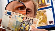 Einen gefälschten 50-Euro-Schein untersucht Klaus-Dieter Ehling, Falschgeldexperte unter der Lupe.