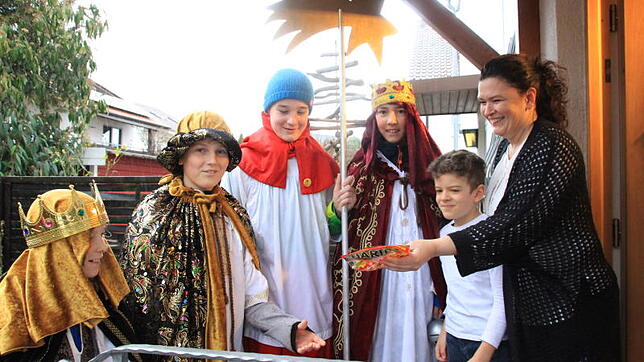 Die Sternsinger Levi (von links), Manuel, Julius und Philipp überbringen Robin und Anita Moser aus Immenstaad ihren Segen und bekommen ...