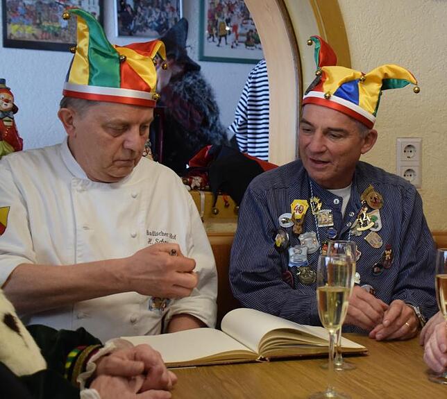 Wirt Hermann Schmeißer und Thomas Strobl schmökern durch das Gästebuch.