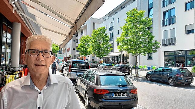 Bürgermeisterkandidat Klaus Schultz in der Hauptstraße, rechts im Hintergrund das Einkaufszentrum Proma und das wiedereröffnete Eiscafé ...