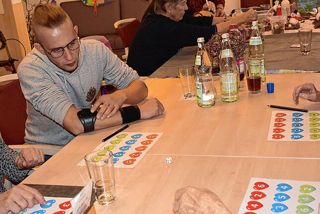 Betreuungskraft Andreas Rapp spielt ein Würfelspiel mit denen, die nicht basteln.