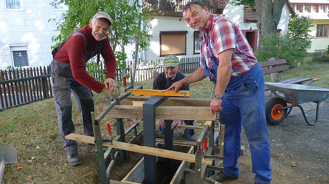 Mitglieder der Heimathausgruppe fertigen das Fundament für die Erinnerungstafel an Pfarrer Karle auf dem Vorplatz der evangelischen ...