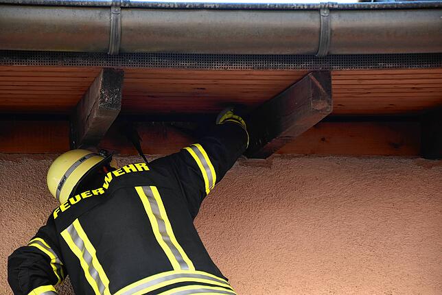 Unter dem Dachvorsprung in rund sieben Meter Höhe wurde von der Feuerwehr der an dünnen Plastikschnüren hängende und verzweifelt ...