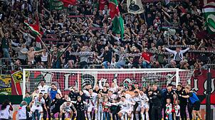 Spieler und Fans des FC Augsburg feiern im April 2024 einen Sieg gegen Union Berlin. Mit dem Bundesligisten verbindet der FCA eine ...