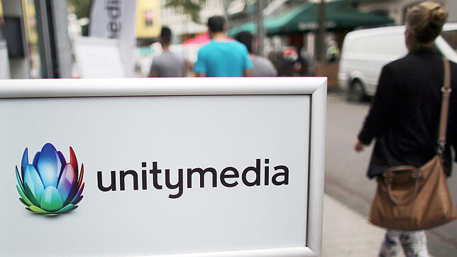 ARCHIV - Eine Frau geht in Köln an einer Filiale des Kabelanbieters Unitymedia vorbei.
