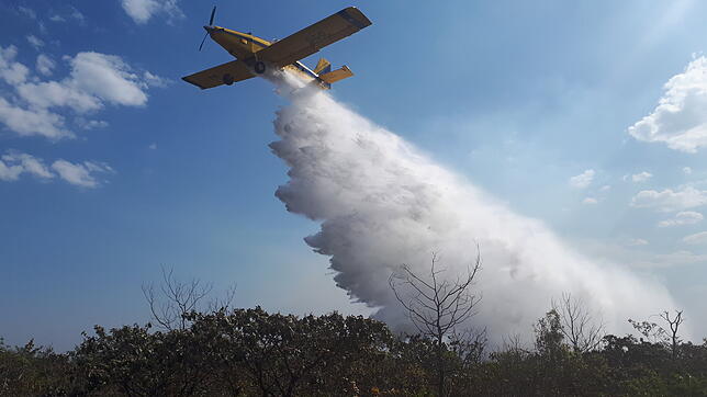 Ein Löschflugzeug fliegt über den Naturpark Chapada dos Guimaraes.