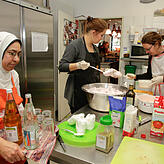 Dalal Haggag Ismail Kaskoush bringt Getränke, Isabelle Arndt und Jacqueline Weiß verteilen das Dessert.