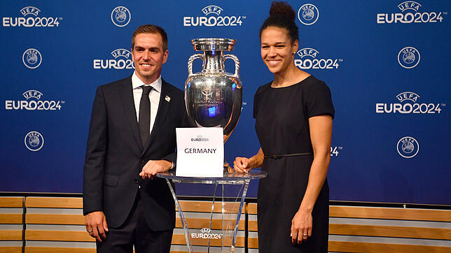 EM-Botschafter Philipp Lahm (l) und die Integrationsbotschafterin Celia Sasic (r) der deutschen Delegation stehen neben dem EM-Pokal ...