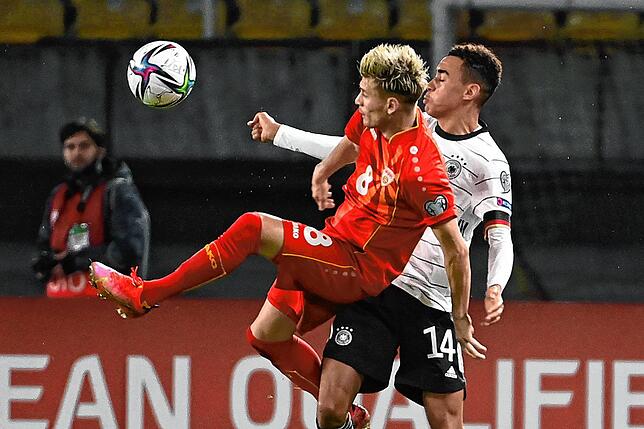 Deutschlands Jamal Musiala (r) und Nordmazedoniens Ezgjan Alioski in Aktion. Fußball WM-Qualifikation am 11.10.2021 in Skopje. ...
