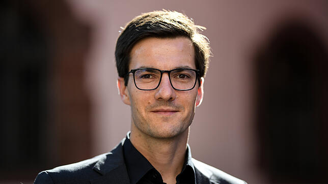 Martin Horn (parteilos), Oberbürgermeister von Freiburg, steht in der Innenstadt vor dem Rathaus.