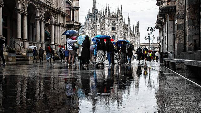 Passanten gehen im Zentrum von Mailand mit Regenschirmen vor dem Dom. In Italien gab es in mehreren Regionen heftige Regenfälle.