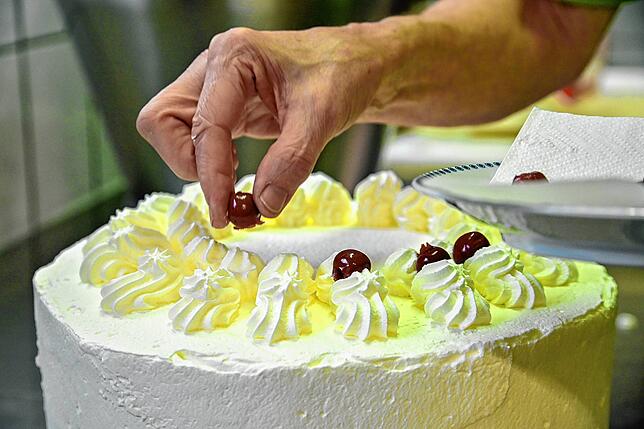 Bei der Schwarzwälder Kirschtorte sind die Kirschen das Tüpfelchen auf dem Sahnehäubchen. Heidi Fleig legt jede einzeln und behutsam auf ...