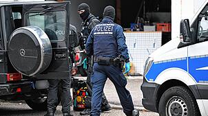 Einsatzkräfte der Polizei durchsuchen ein Fahrzeug vor einem Haus in Weil der Stadt.