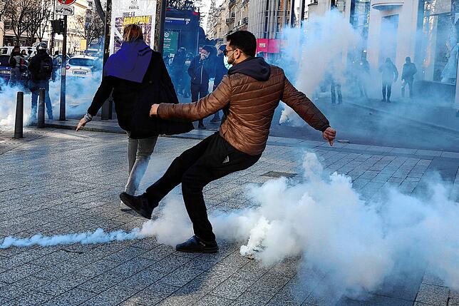 Ein Demonstrant steht während einer Demonstration auf der Avenue des Champs-Elysees im Rauch einer Tränengasgranate. Frankreichs Polizei ...