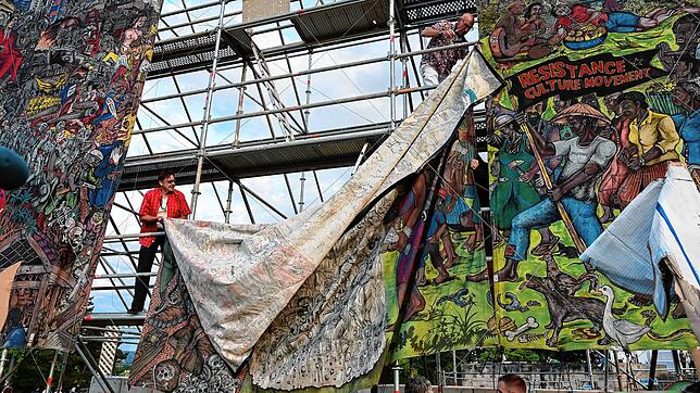documenta-Mitarbeiter bauen das umstrittene Großbanner „People‘s Justice“ des indonesischen Künstlerkollektivs Taring ...