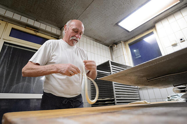 Bäckermeister Thomas Frank schlingt in Stuttgart schwäbische Brezeln.