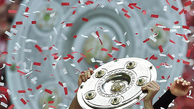 Ein Spieler des FC Bayern hält die Meisterschale. Mit dem Start der Bundesliga kehrt der deutsche Fußball nach dem desaströsen WM-Sommer ...