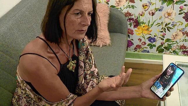 Orly Louk, Tante der 22-jährigen Shani Louk, sitzt auf einer Couch und zeigt ein Handyfoto ihrer Nichte. In einer beispiellosen Aktion ...