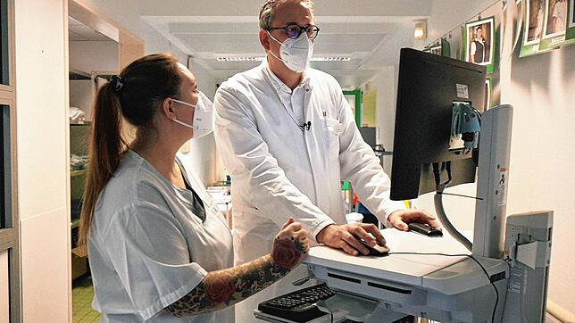 Hinrich Bremer und die examinierte Gesundheits- und Krankenpflegerin Laura Scapin besprechen anhand von Bildern am Monitor den ...